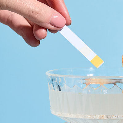 person holding a drink spike test strip